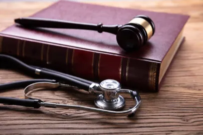 A judge’s gavel resting on a law book beside a stethoscope